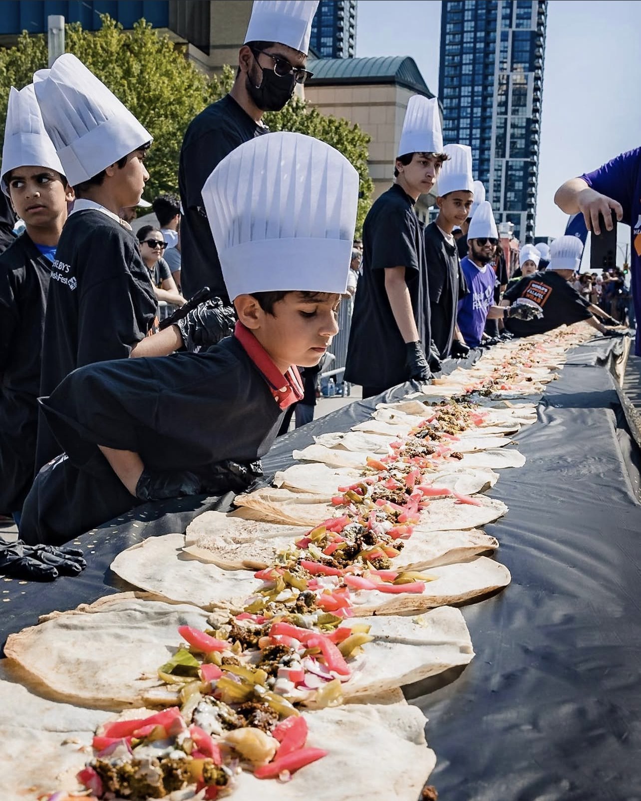 Virtue25 reel poster — chef on the falafel wrap line.